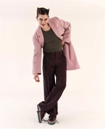 Hero Fiennes Tiffin in a pink jacket and dark trousers posing against a plain white background for GQ Australia
