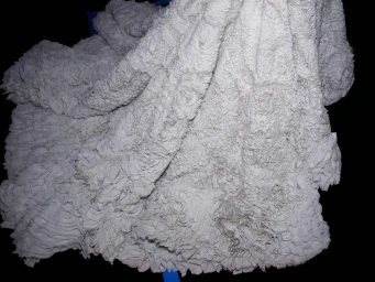 Close-up of heavily ruffled white textured fabric draped over a dark background backstage at Jason Wu.