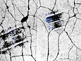 Detailed close-up shot of cracked white asphalt surface featuring prominent black and blue tire marks.