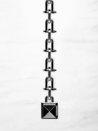 Macro shot of a shiny silver metal chain with U-shaped links and a square lock against a bright white marble background.