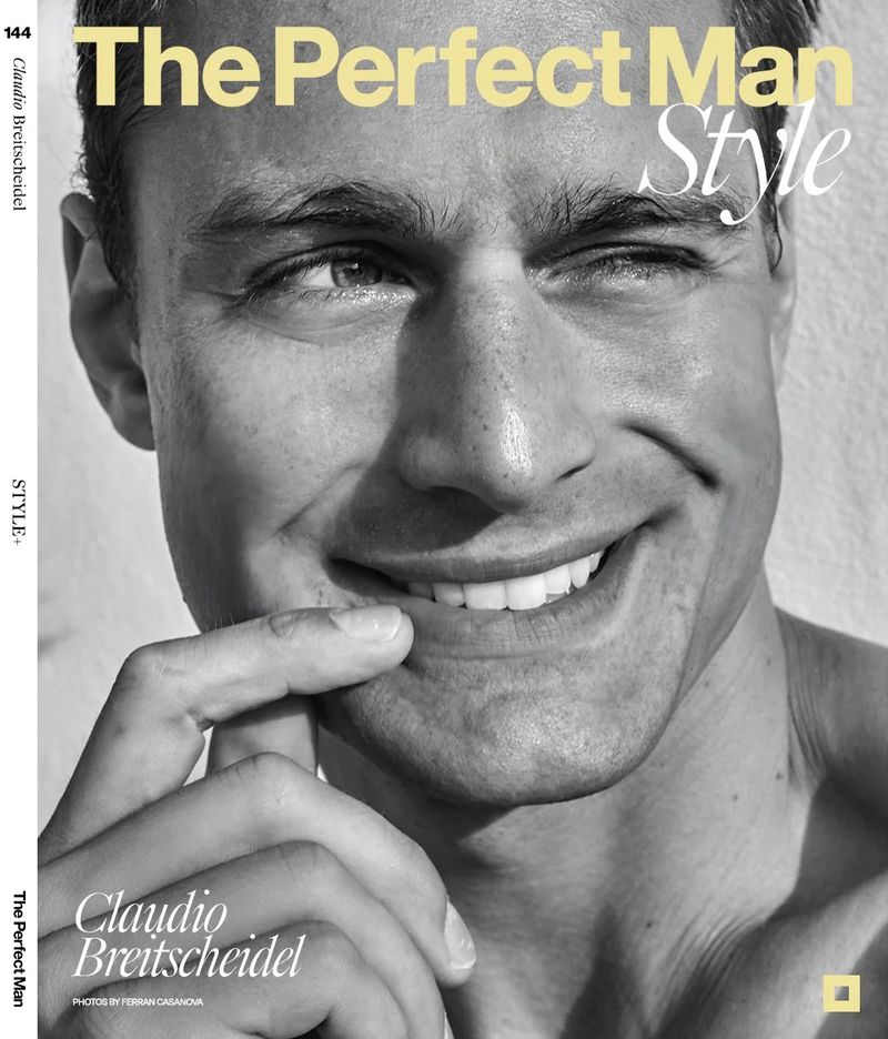 Close-up portrait of a light-skinned adult male model with a slight smile, set against a neutral background, featured on a magazine cover.