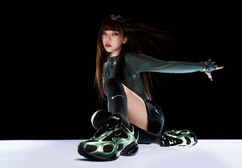 Woman poses in a studio wearing athleisure clothing and Nike sneakers. Fashion-forward athletic aesthetic with dynamic lighting and dark backdrop.
