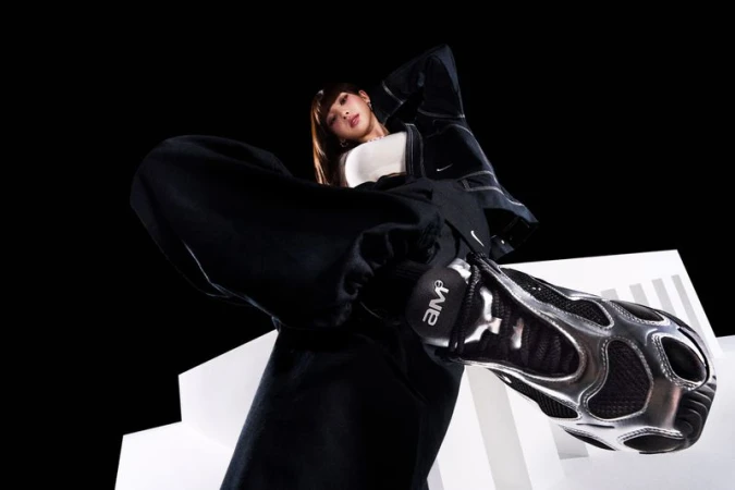 Stylish athletic shoe and fashion outfit on a young adult female posing against a studio backdrop with white geometric shapes.