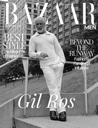 Black and white fashion magazine cover featuring a mature male model in white leaning against a railing with city buildings in background.