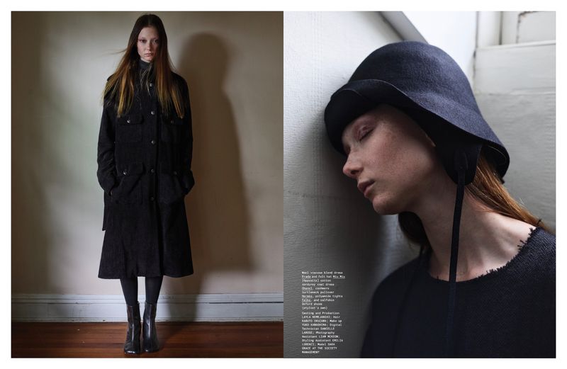 Editorial fashion shot: a slender, fair-skinned model in a long black coat and ankle boots stands against a neutral wall. A close-up shows a second model.