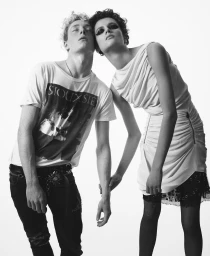 Two models leaning together against a bright white background for Harper's Bazaar Italia
