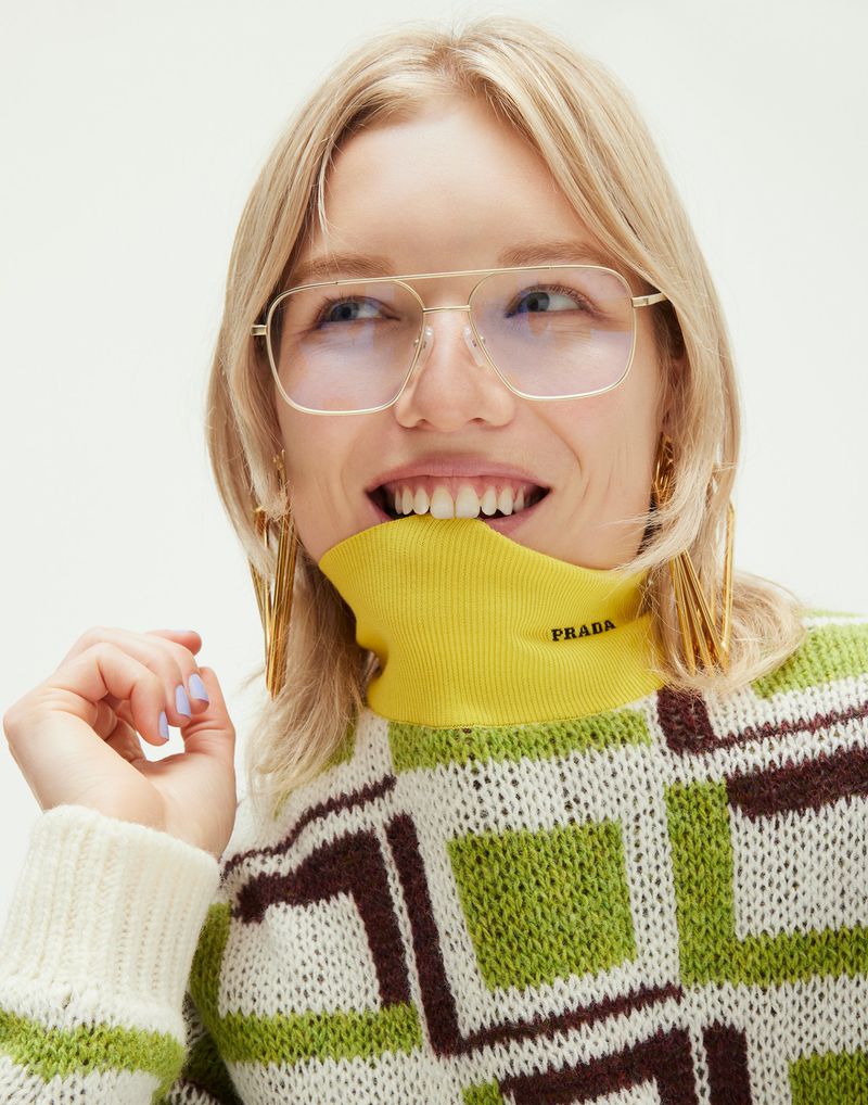 Model wearing wire-frame glasses and a patterned sweater biting her collar for Marie Claire Australia by Justin Woo