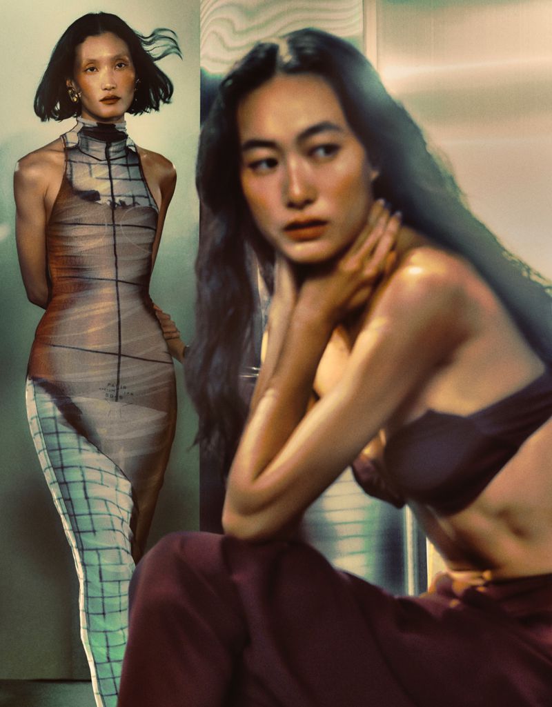 Two Asian women pose in a studio: one in a geometric-patterned dress, the other in a top and pants, against a neutral backdrop.