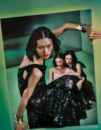 Three Asian women in a retro-style fashion shot; one woman in foreground wearing a black gown and gold cuff bracelet. Fashion editorial.