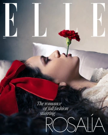 Elle magazine cover featuring a woman with a red flower in her mouth, laying down with a red bow in her hair, in a soft, diffused light.