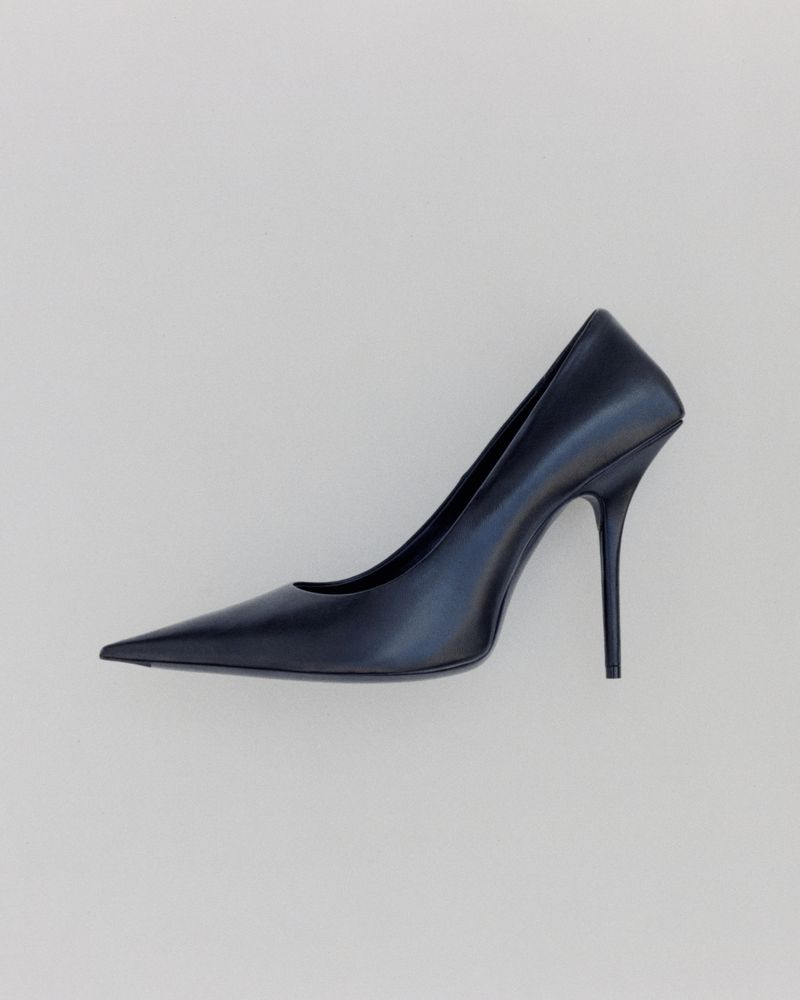 Elegant black high heel shoe with a pointed toe stands gracefully on a clean, neutral background, showcasing modern fashion footwear.