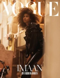 Imaan Hammam in a black leather outfit leaning against a wall outdoors for Vogue Netherlands