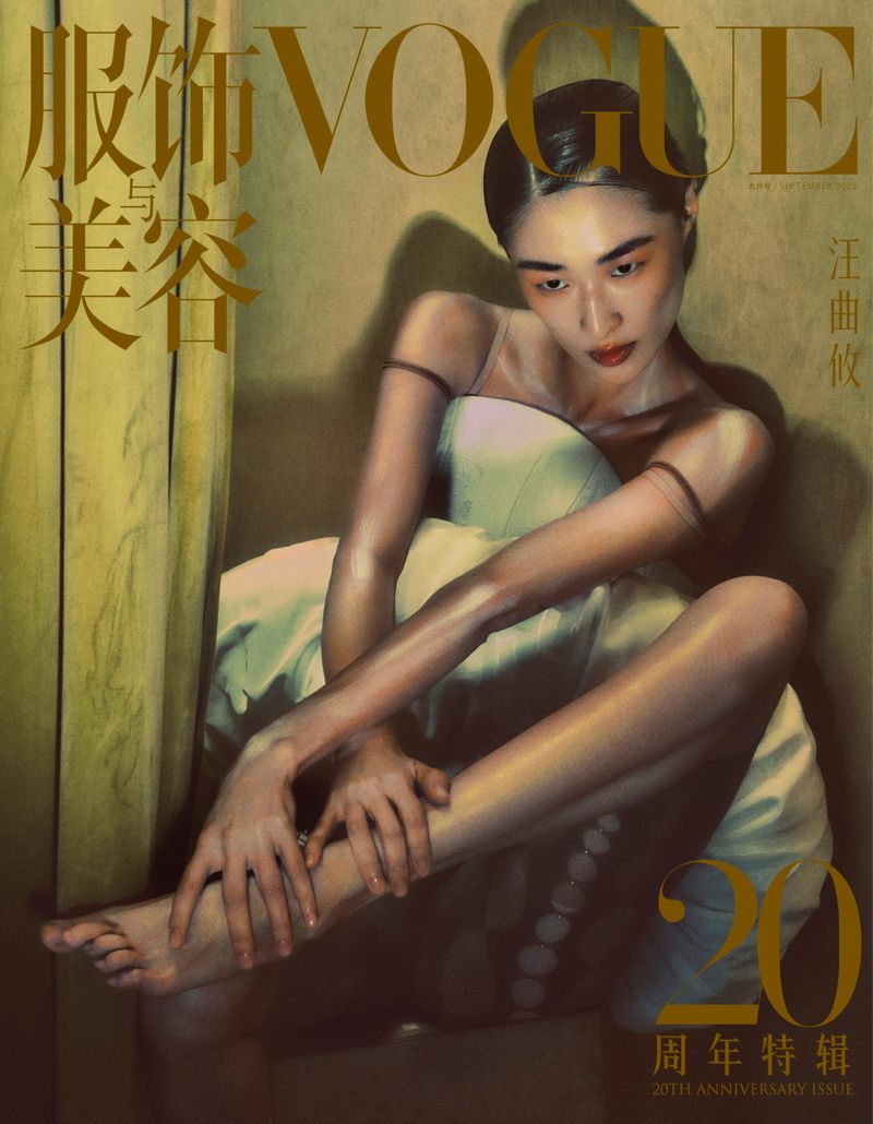 Vogue magazine cover featuring a slender Asian woman in a strapless dress, seated with knees up and arms wrapped around legs in studio light.