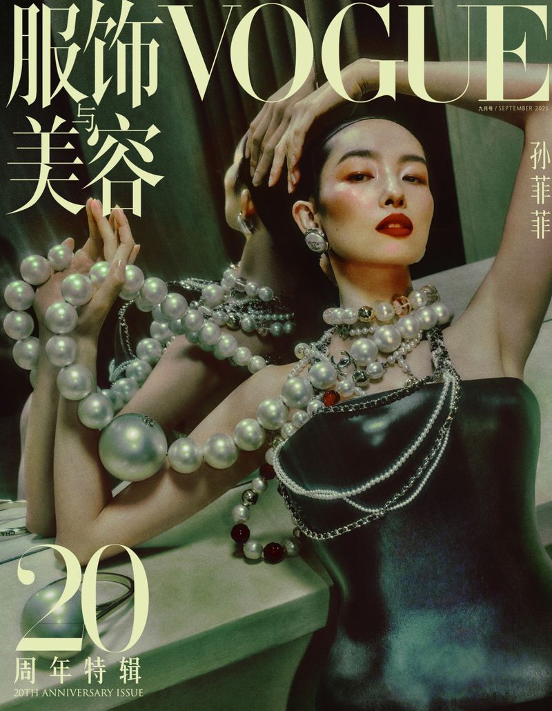 Vogue cover featuring a woman with dramatic makeup, pearl necklaces, and a black dress, striking a pose in a studio setting.