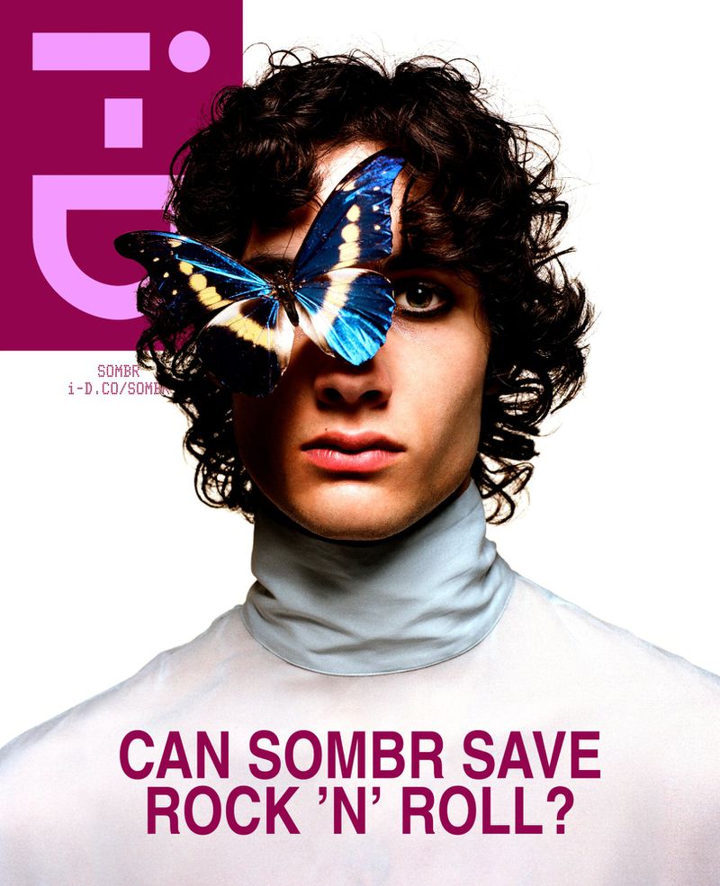 Fashion portrait of androgynous person with dark curly hair, wearing a white turtleneck, featuring a butterfly over one eye. Magazine cover.