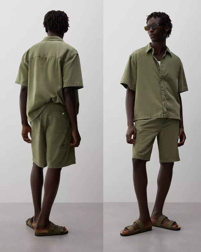 Olive-toned linen matching set showcased on a man, featuring a button-up shirt and shorts, styled with sunglasses and sandals on a neutral background.