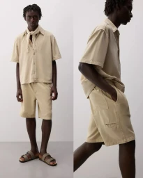 Model Godwin Dekou wearing a beige short-sleeve shirt and matching shorts for the Lefties S/S 25 collection.