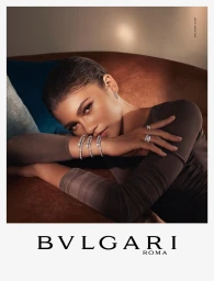 Zendaya wears diamond Serpenti bracelets and rings while resting her arms on a brown velvet sofa in a Bvlgari campaign.