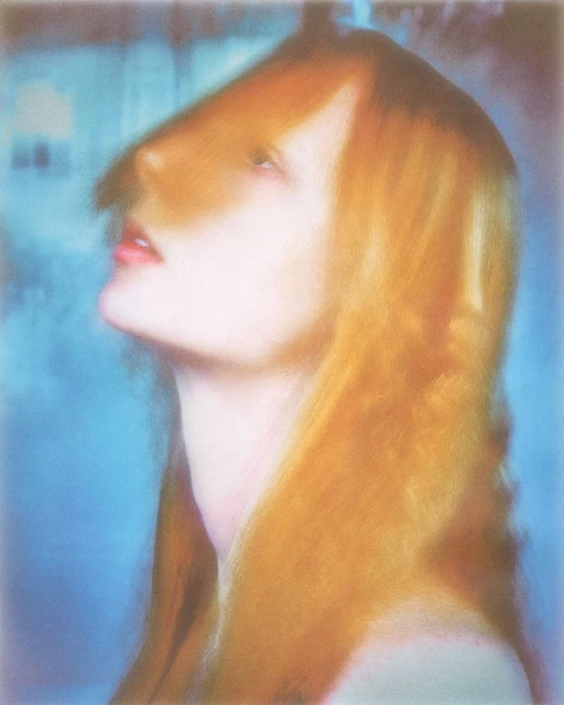 Portrait of a woman with auburn hair looking upwards, bathed in soft lighting with a blurred, dreamlike quality. Beauty shot.