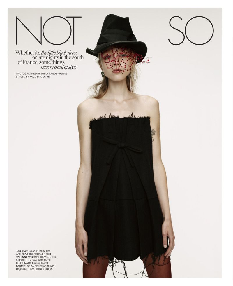 Fashion editorial shot featuring a slender woman wearing a black strapless dress and a black hat with a red beaded veil.