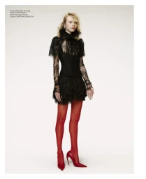 Model in black lace dress and red tights against a plain light background for Elle U.S.
