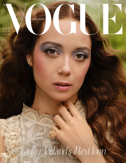 Close-up portrait of Laufey for Vogue Scandinavia wearing a patterned lace top with blue eyeshadow and a textured gold ring.