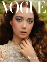 Close-up portrait of Laufey for Vogue Scandinavia wearing a patterned lace top with blue eyeshadow and a textured gold ring.