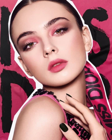 Close-up of a woman with pink eyeshadow and lipstick, posing against a magenta background with the "Miss Dior" logo and black accents.