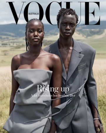 Vogue Australia cover featuring models Adut Akech and her brother, Bior Akech, wearing grey-toned, fashion-forward clothing, set against a natural landscape.