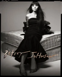 Christina Ricci wearing a strapless black evening dress seated on stacked mattresses for Betsey Johnson.