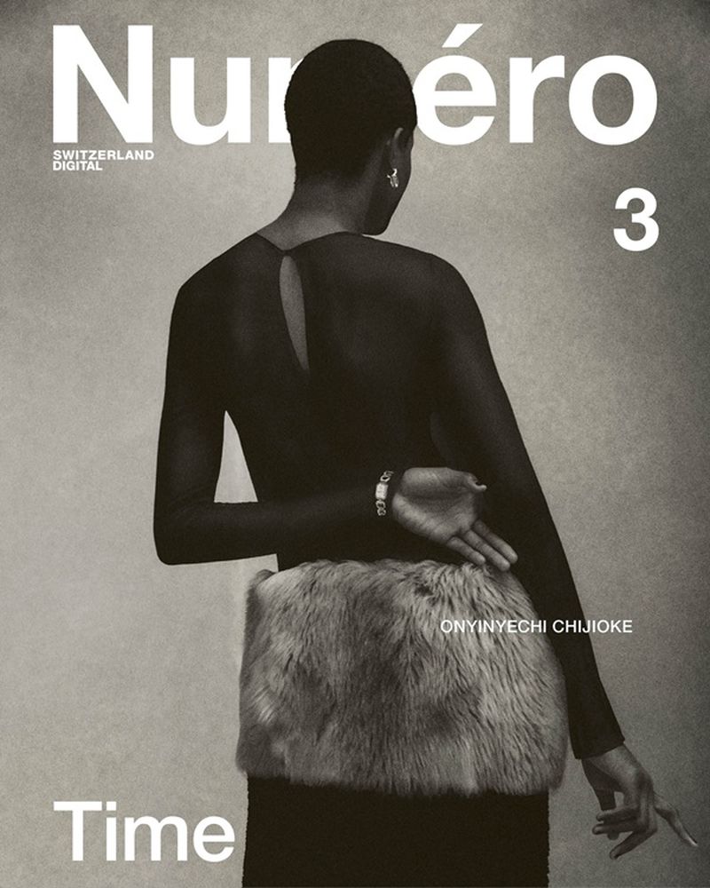 A woman with short dark hair is seen from the back, wearing a sheer top and skirt with fur detail, for a Numero magazine cover.