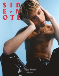 Portrait of Troye Sivan seated shirtless wearing black trousers against a light blue backdrop for Side-note