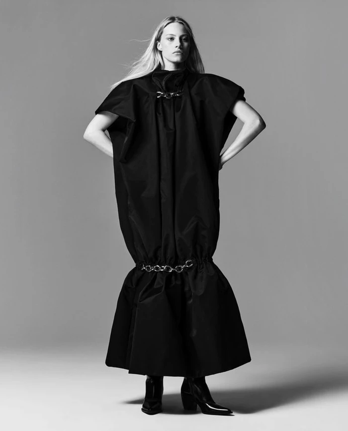 Model Annie Arnander wearing a black voluminous dress against a grey studio backdrop for Vogue Scandinavia.