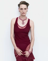 Model Veronika Kunz wearing burgundy layered top and ornate necklace for Vogue Ukraine