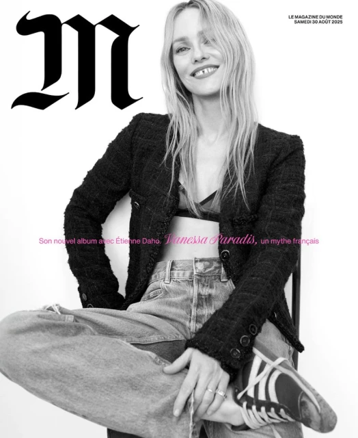 Vanessa Paradis poses for a magazine cover wearing a black tweed jacket, light wash jeans, and sneakers against a white background.