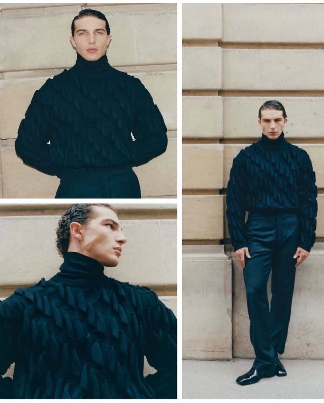 Man wearing a dark textured turtleneck sweater and trousers posing against a stone wall