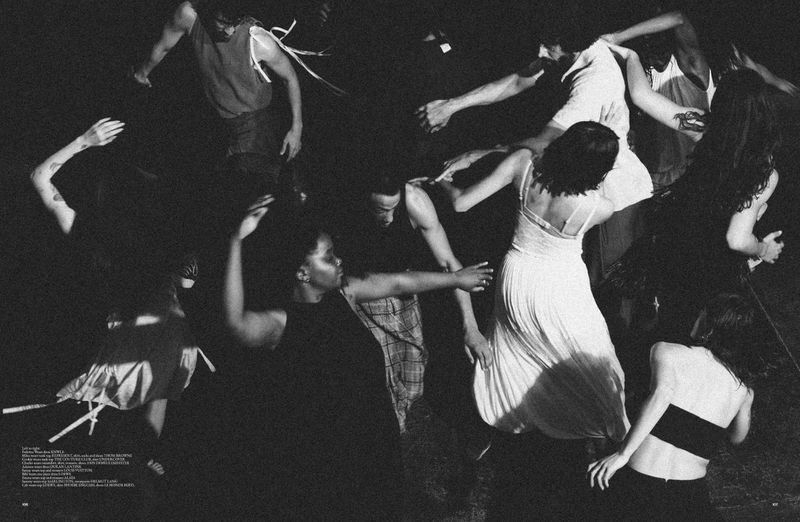 A group of people are dancing in a dimly lit area, moving their arms, wearing casual clothing, with an overhead camera angle.