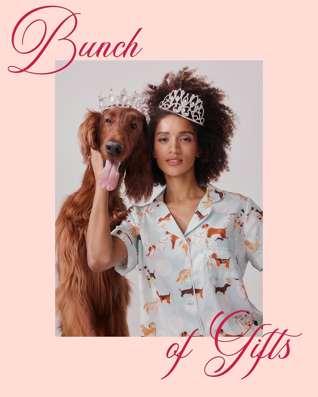 Adult woman and an Irish Setter dog pose indoors, both wearing tiaras. The woman wears a dog-print pajama top with short sleeves.