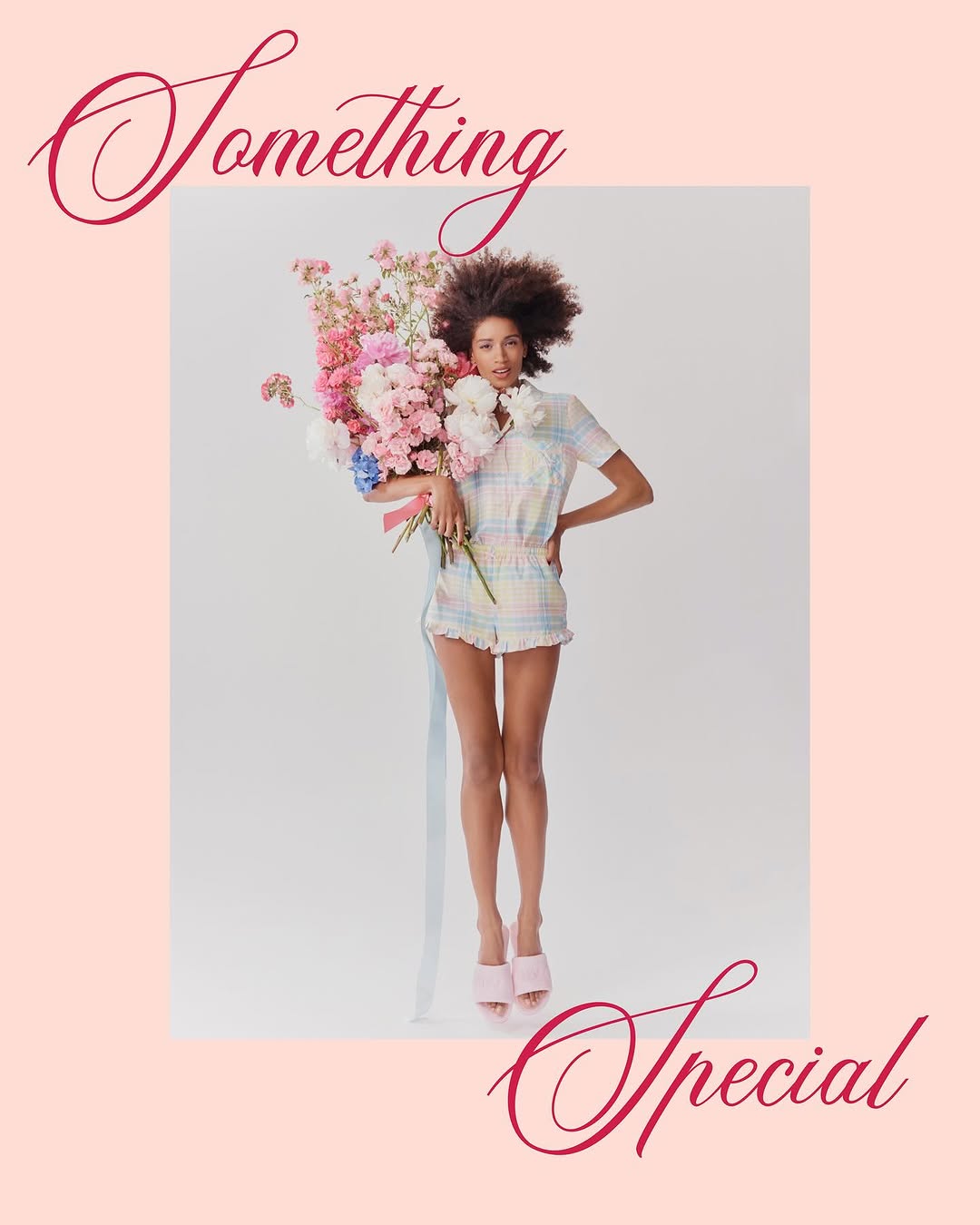 Woman in pastel romper holds large bouquet against pink background, showcasing fashion, spring, and floral themes.