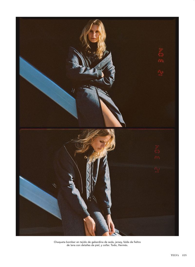 Stylish blonde woman poses in a bomber jacket dress on a staircase in a fashion editorial, showcasing fall colors and shadows.