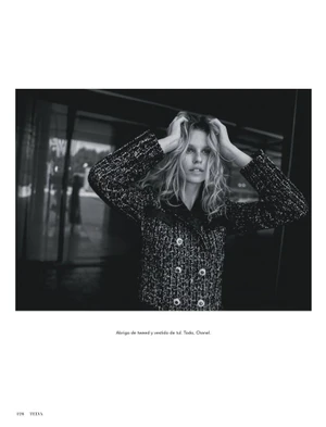 Black and white fashion portrait of Mariina Keskitalo wearing a tweed coat with hands in her hair for Telva.