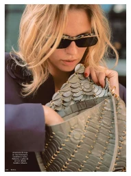 Blonde model wearing sunglasses holding an ornate grey textured handbag for Telva fashion editorial.