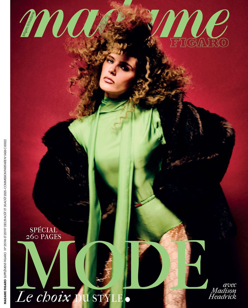 Magazine cover featuring a female model wearing a green bodysuit and dark fur coat against a red background with green text overlay.