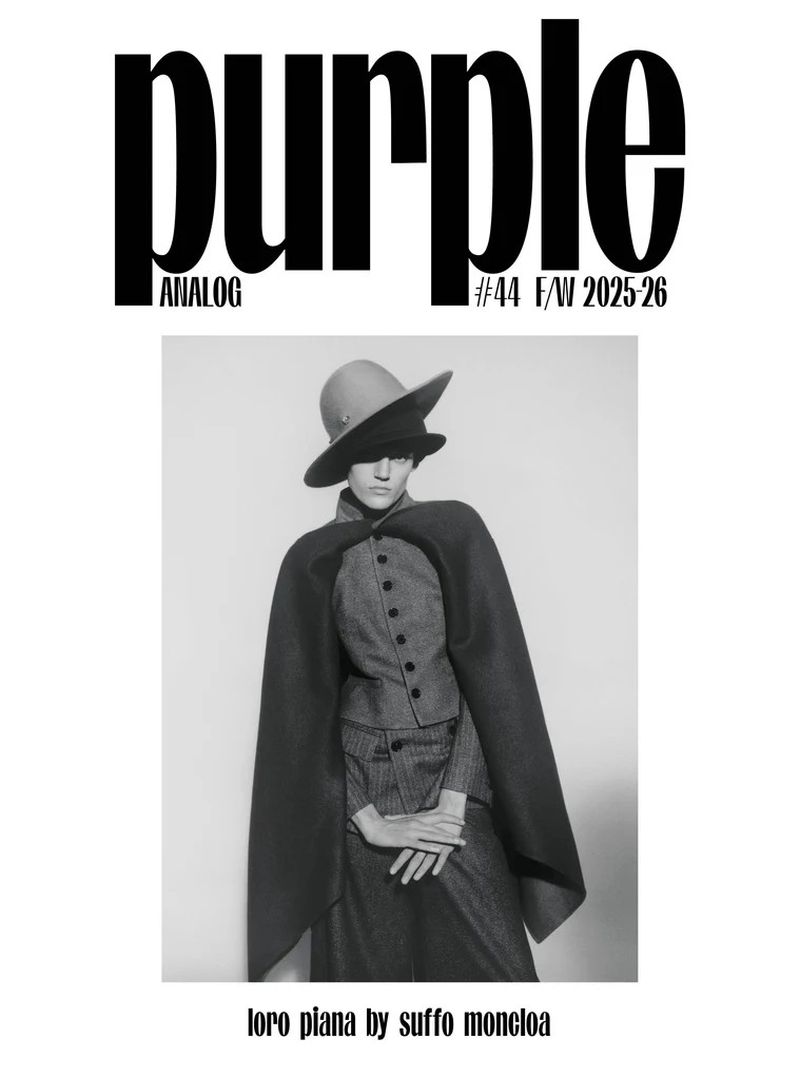 Monochrome fashion editorial featuring a woman in a hat and cape, styled in muted tones against a plain backdrop, reminiscent of vintage style.