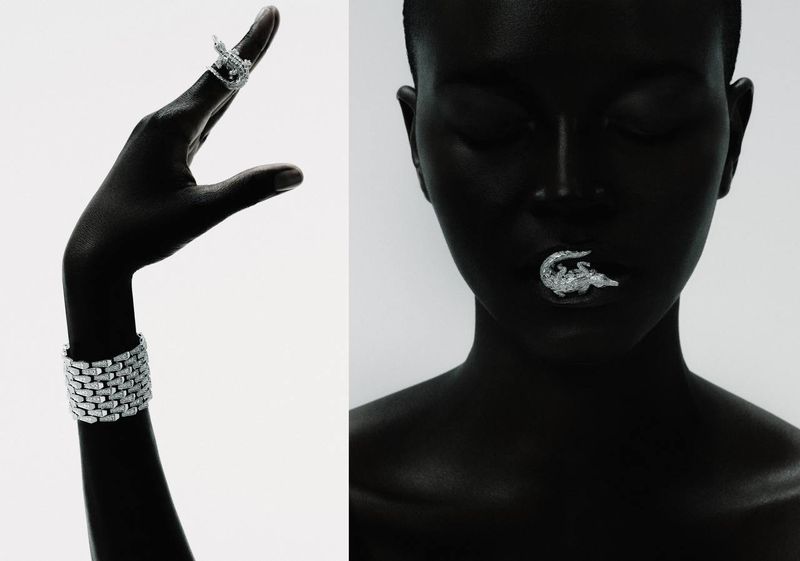 Monochromatic shot featuring an adult Black model showcasing silver jewelry, including a ring, a bracelet, and a crocodile lip ornament.