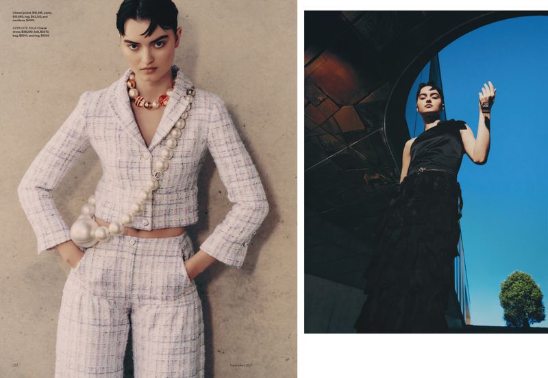 Fashion editorial shot featuring a woman in a tweed outfit with pearl accessories and another woman in a black dress against a blue sky.