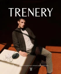 A man in a dark jacket and neutral shirt seated at a restaurant table for Trenery campaign