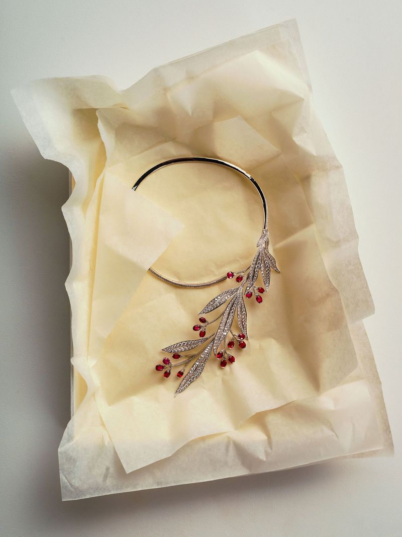 Elegant silver and crystal choker on wrinkled tissue paper, perfect for fashion, beauty, or luxury jewelry ad campaigns.