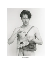 Monochrome portrait of a male model wearing leather shoulder bags and holding a small flower against a light background