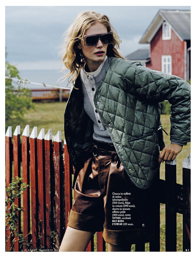 Outdoor fashion shot features a woman in a quilted jacket, sunglasses, and shorts, set against a red fence and rural backdrop with a red house.